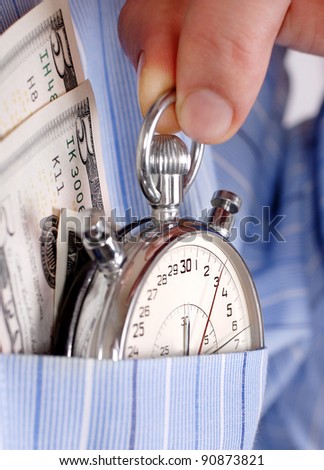 Close up view on stopwatch with banknotes into the pocket of  man shirt
