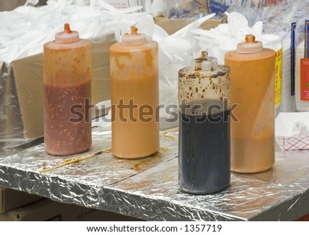 Sauces in plastic squeeze bottles at a food festival on 9th Avenue in New York City.