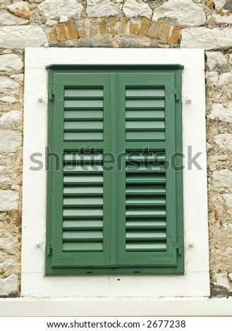 Green shuttered window of an old stone house in Sibenik Croatia.
