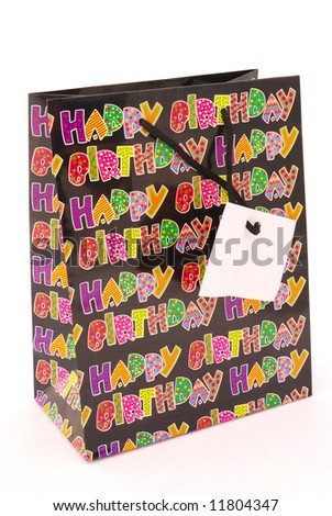 A colorful happy birthday gift bag with plain tag isolated on white background