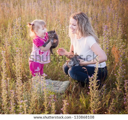little girl and mother with cats outdoor