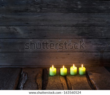green candles on old wooden background