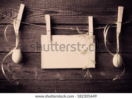 easter egg and paper attach to rope with clothes pins on wooden background