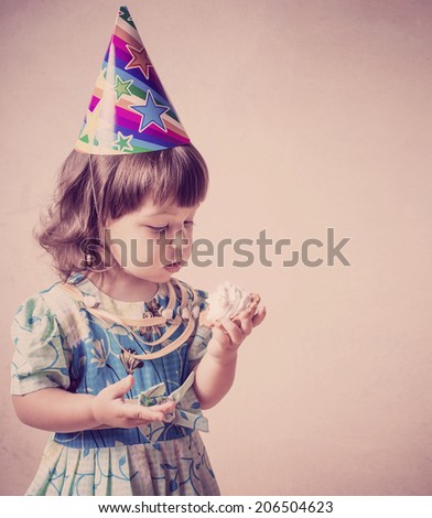 little girl eating cake in a festive cap  in vintage style