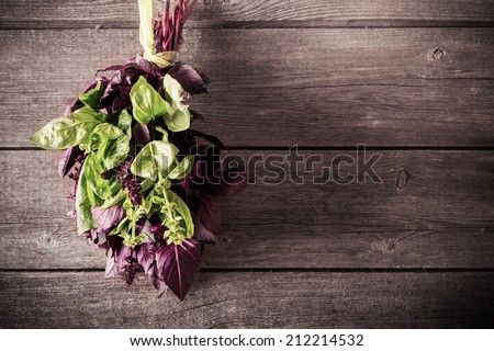 bunch of purple and green basil on a wooden background