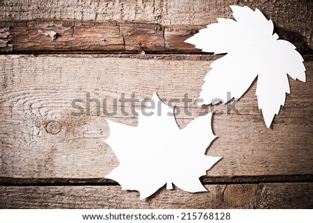 wooden background with paper leaves