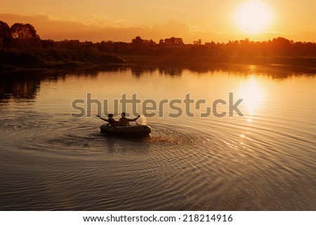happy couple in boat at sunset
