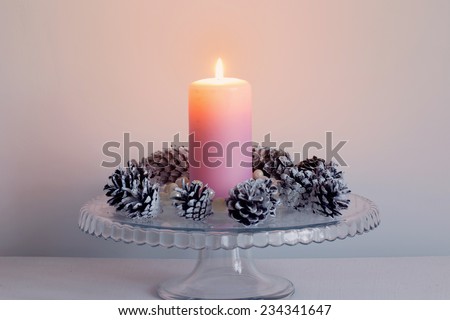 Christmas candle burning bright with  pine cone