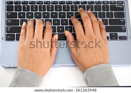 Closeup of woman hands typing on laptop keyboard