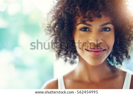 Photo of Portrait of smiling young black woman with sunlight flare and copy space
