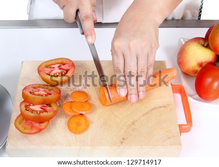 Image of woman cutting carrot and tomato prepare vegetables food for dinner