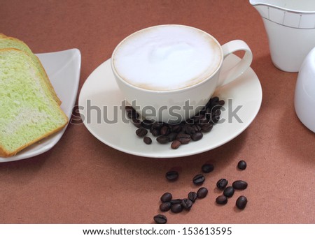 close up image of hot coffee and bread on table in coffee shop