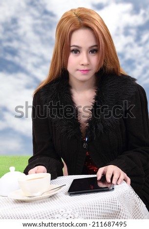 beautiful asian woman with hot coffee and tablet on table