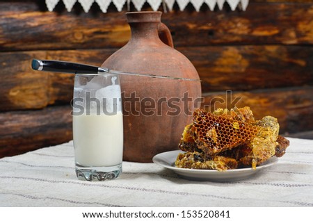 honey comb and a clay jug with milk