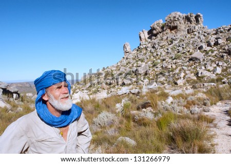 Old man in bedouin clothes looks at mountains. Shot in Krakadouw, Cederberg Mountains, near Clanwilliam, Western Cape, South Africa.