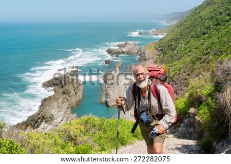 Happy old man just reaches the top of hill. Shot on the Otter trail in the Tsitsikamma National Park, Garden Route area, Western Cape, South Africa.