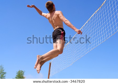 Teenager jumps high for spike while playing beach volleyball. Shot in Ukraine.