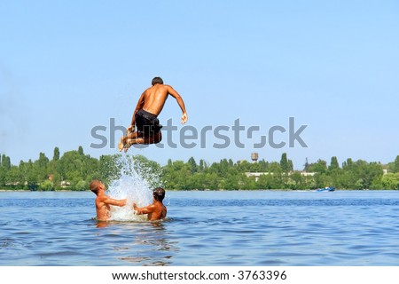 Teen jumps into water from friends\' hands. Shot in June, near Dnieper river (Dniepropetrovsk, Ukraine).