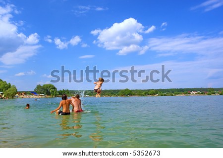 Men push girl high to jump in water. Shot in July in Kyiv suburb, Ukraine.