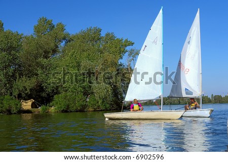 Two friends on yachts on river. Shot in July, Dnieper river, Ukraine.