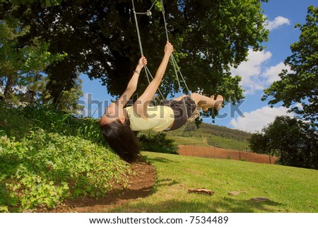 Happy girl (mulatto/colored) on swing in hot summer day. Shot near Stellenbosch, Western Cape, South Africa.