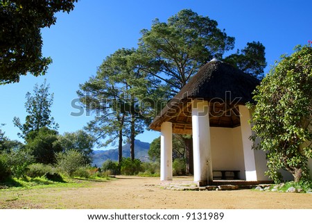 Thatch-roof shelter in front of forest. Shot in August in Jan Marais Nature Reserve, Stellenbosch, South Africa.