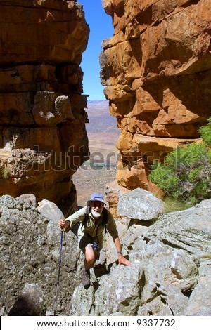 Happy old man climbs in mountains. Shot in Wolfberg Mountains, Cederberg, Western Cape, South Africa.
