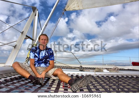Relaxing man sits on desk under sail. Shot near Waterfront, Cape Town, Western Cape, South Africa.