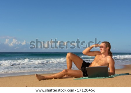 Young man looks far ahead while lying with notebook on beach. Shot in Sodwana Bay nature reserve, KwaZulu-Natal province, Southern Mozambique area, South Africa.