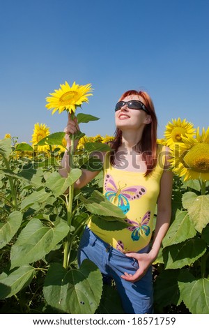 Red-hair Ukrainian girl holds a sunflower as a radar. Shot in Ukraine.