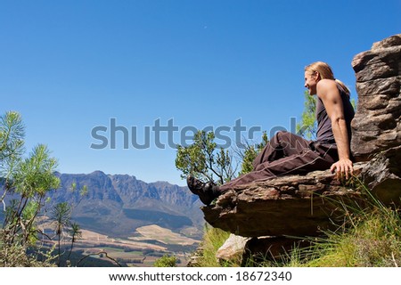 Smiling climber sits on top of mountain. Shot in Helderberg Mountains Nature Reserve, near Somerset West/Cape Town, Western Cape, South Africa.