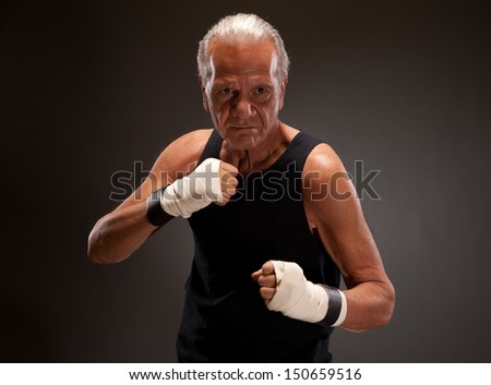 Senior fighter posing against dark background