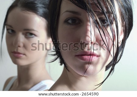two attractive girls looking into the camera. Soft focused. Focal point is on the right face.