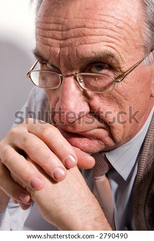 Portrait of concentrated old man in glasses