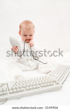 little baby playing with two computer keyboards and mouse