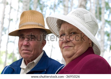 happy couple of seniors in the park. Soft-focused, focal point is on woman