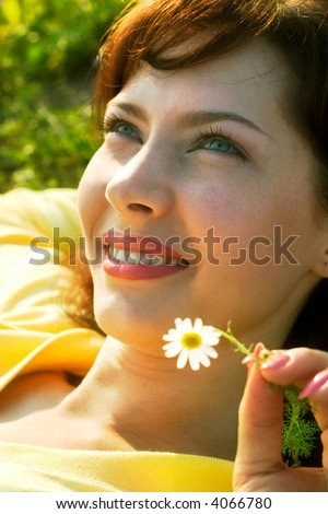 beautiful girl with chamomile lying in the rays of sun. Soft-focused, focal point is on front eye