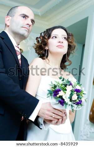 Young couple in wedding wear with bridal bouquet. Special toned photo f/x