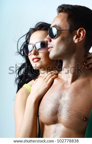 Portrait of sexy stylish young couple macho man and woman both wearing sunglasses