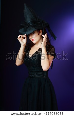 Fantasy magic portrait of sexy beautiful woman with red hair and witch hat