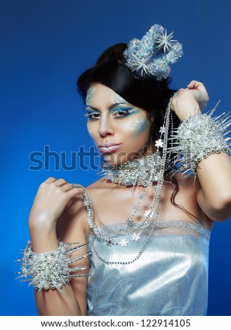 Ice-queen. Young woman in creative image with silver blue artistic make-up and perfect hairstyle.