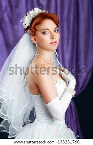 beautiful sexy bride red haired girl woman in white wedding dress with hairstyle and bright makeup in interior