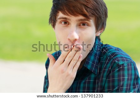 young man making face and cover his mouth by his palm
