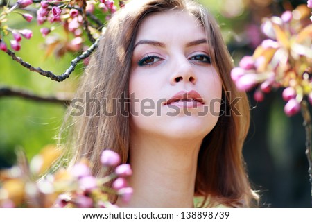 Portrait of smiling beautiful young woman enjoying in spring park