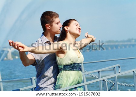 Couple have fun on the bank of a river. Young active people. Outdoors