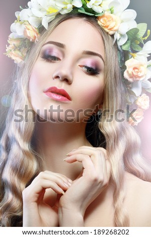 Beautiful Girl With Flowers on Her Head.Beauty Model Woman Face. Perfect Skin. Professional Make-up.Makeup. Fashion Art
