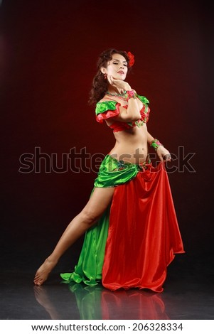 professional dancer beautiful woman dancing in green and red costume on black