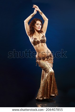 Beautiful professional belly dancer in gold costume