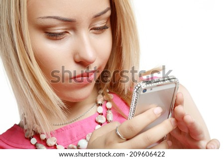 Beautiful blonde using mobile telephone or smartphone and smiles in doubt