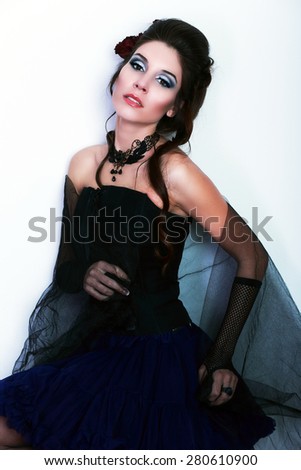 beautiful fashion vampire victorian style woman posing near white wall